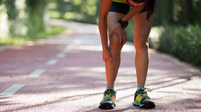 Female runner suffering with pain on sports running knee injury